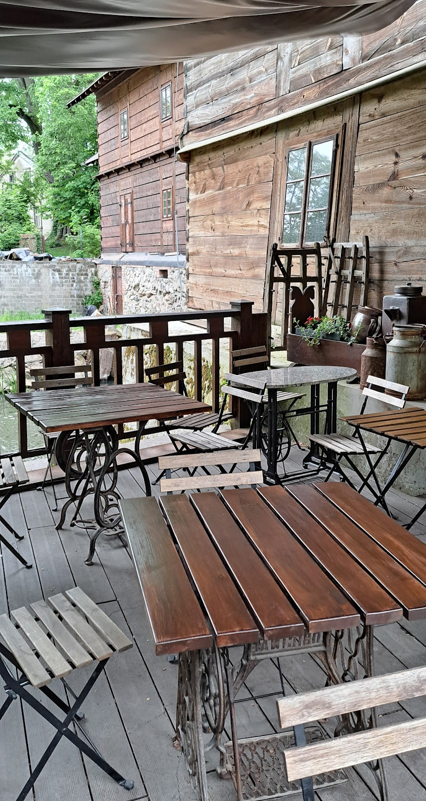 Drewniana weranda z prostymi stolikami i krzesełkami - bar w osadzie